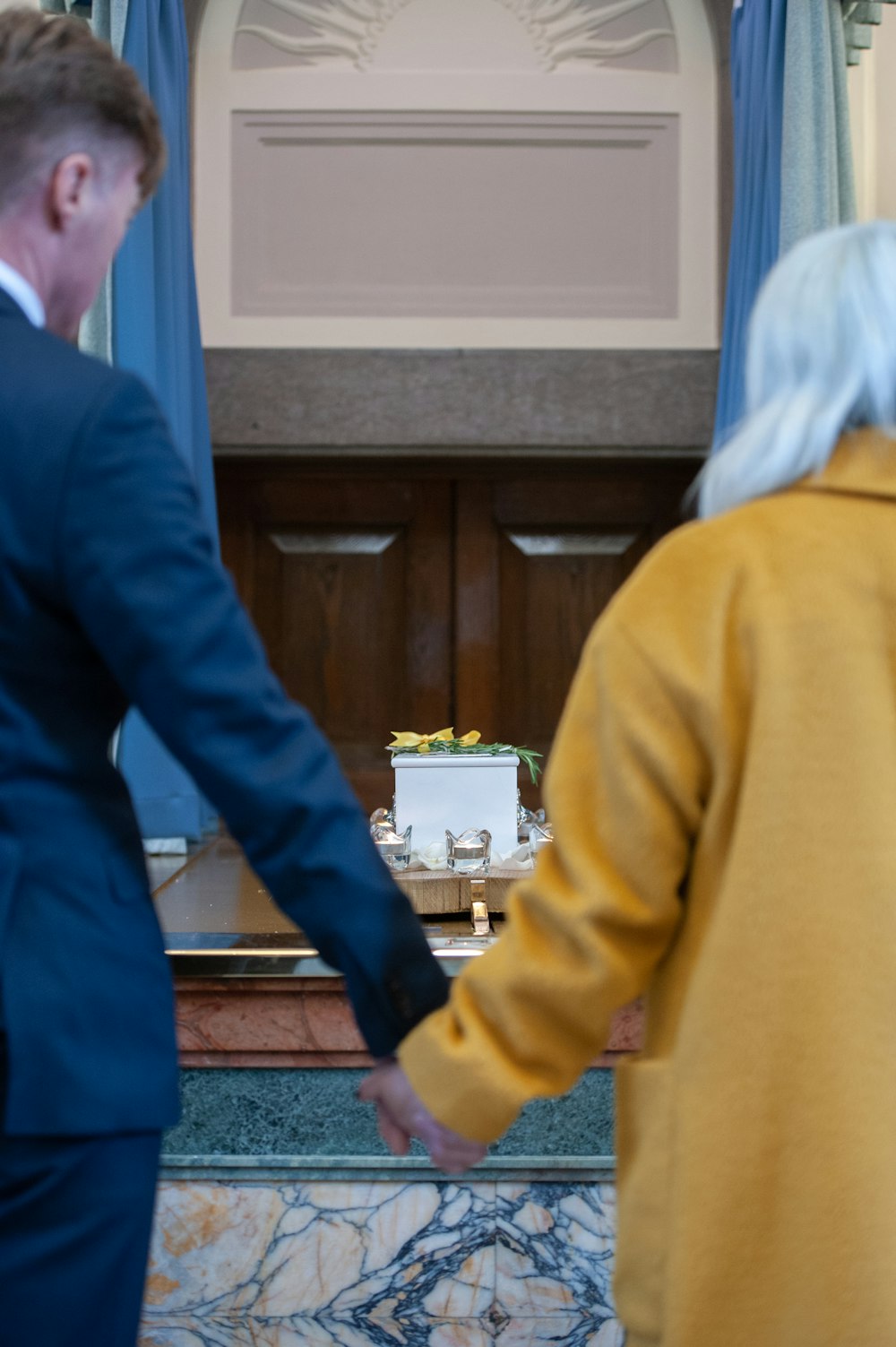 um homem e uma mulher de mãos dadas na frente de uma mesa