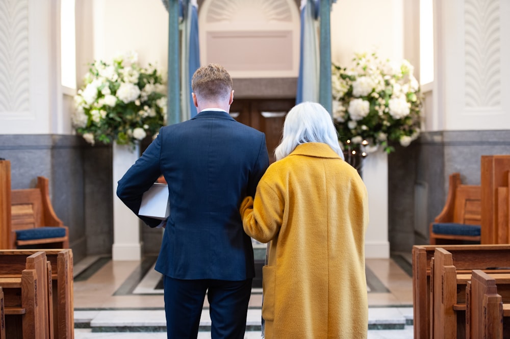 a man and a woman standing in front of a church