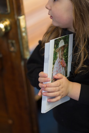a young girl holding a photo of herself