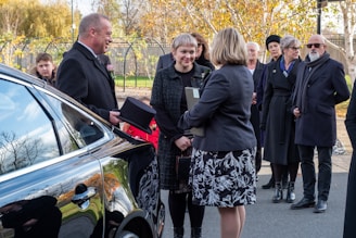 a group of people standing around a car