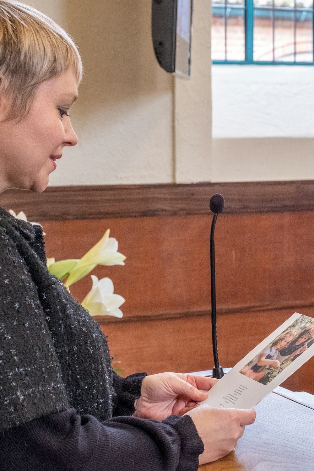 a woman sitting at a table reading a book