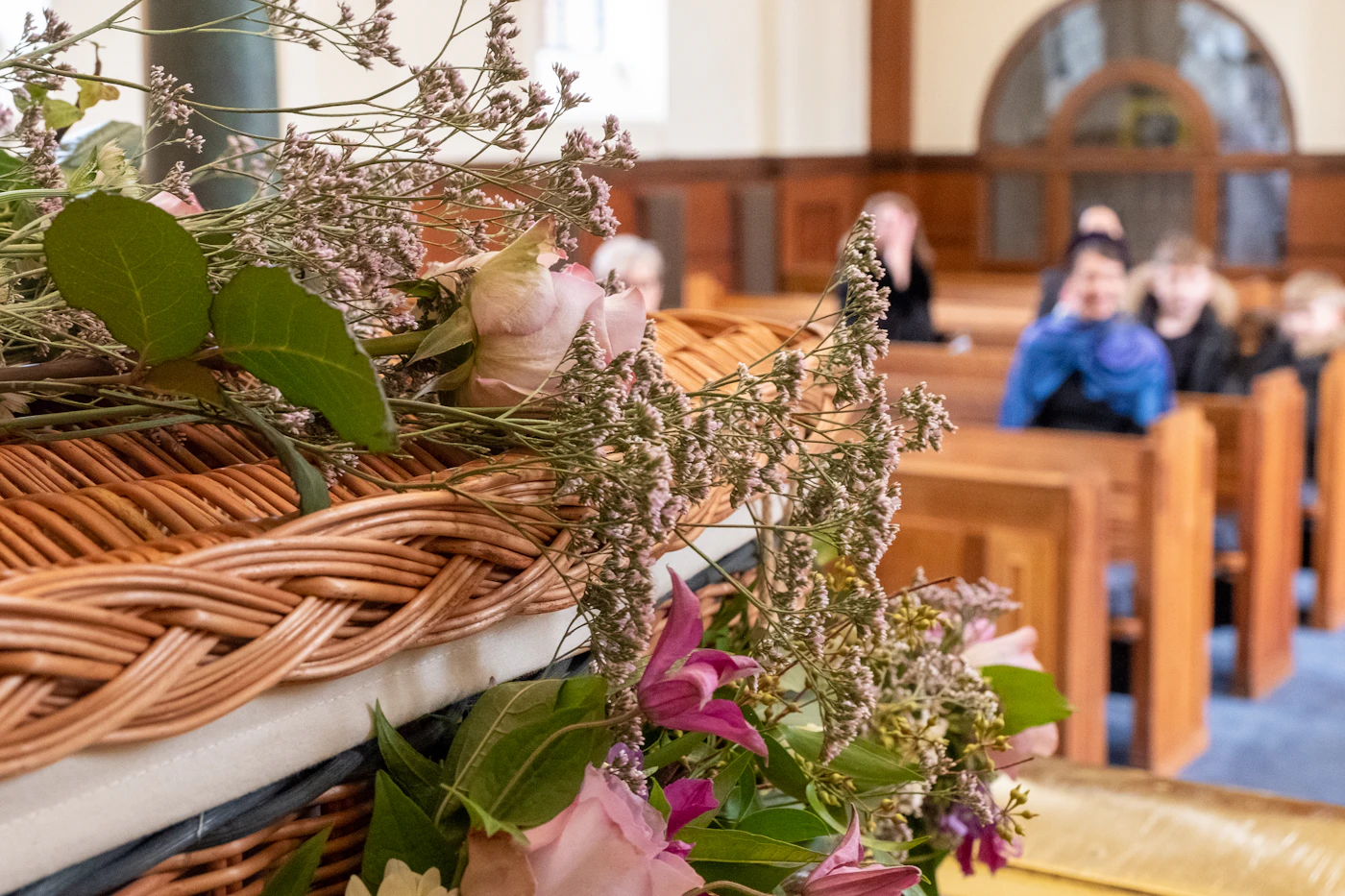 Vintage church decor ideas for traditional ceremonies — Floral bouquets tied with ribbon adorn the ends of wooden church pews.