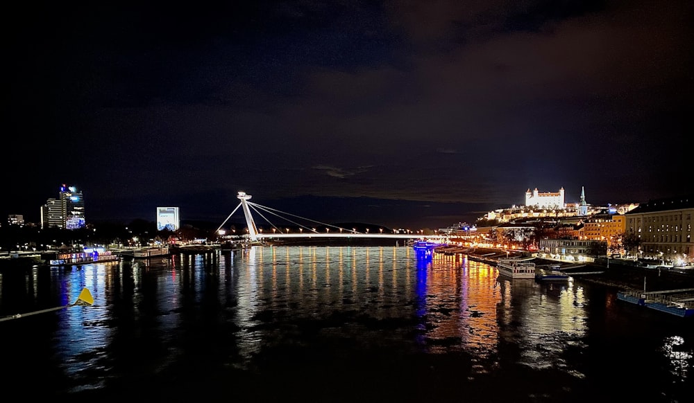 uma vista noturna de uma ponte sobre um corpo de água