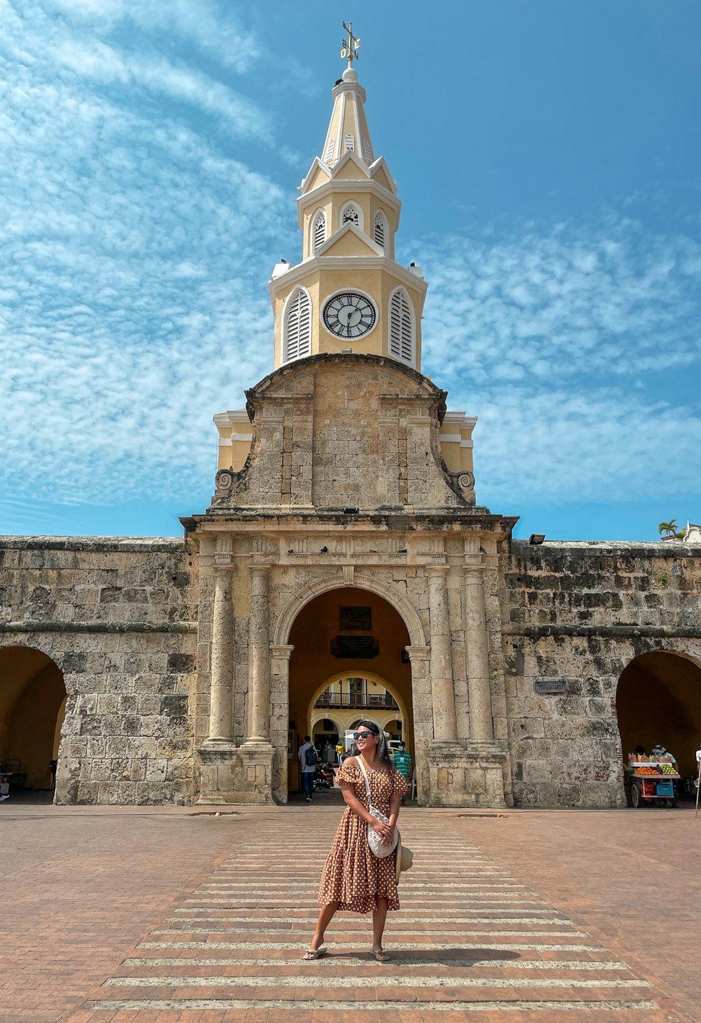 a woman taking a picture of a clock tower