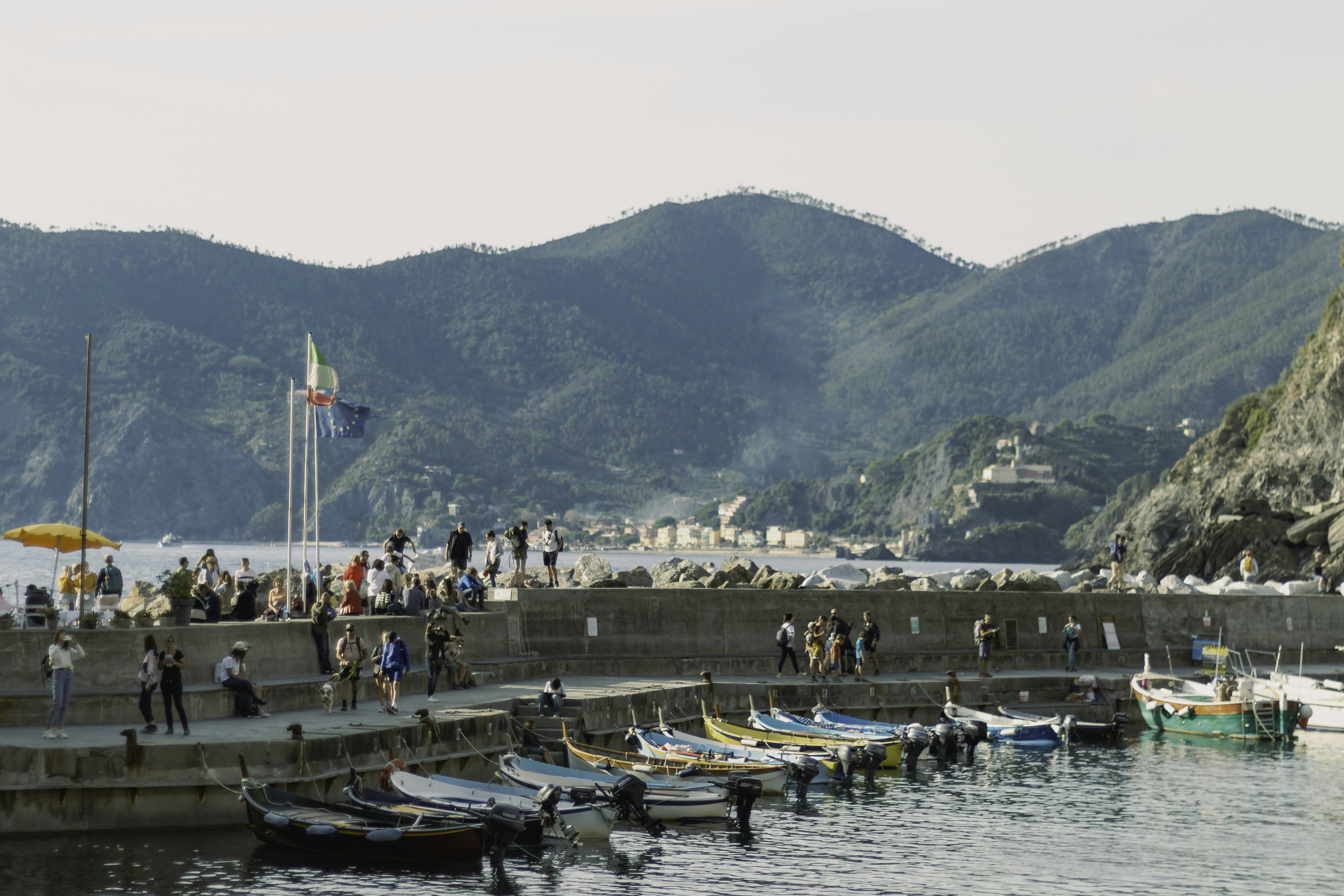a group of people standing on a pier next to boats