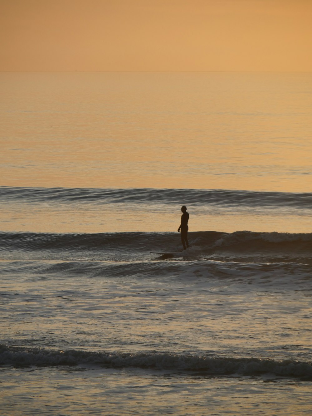 바다에서 서핑 보드에 서있는 사람