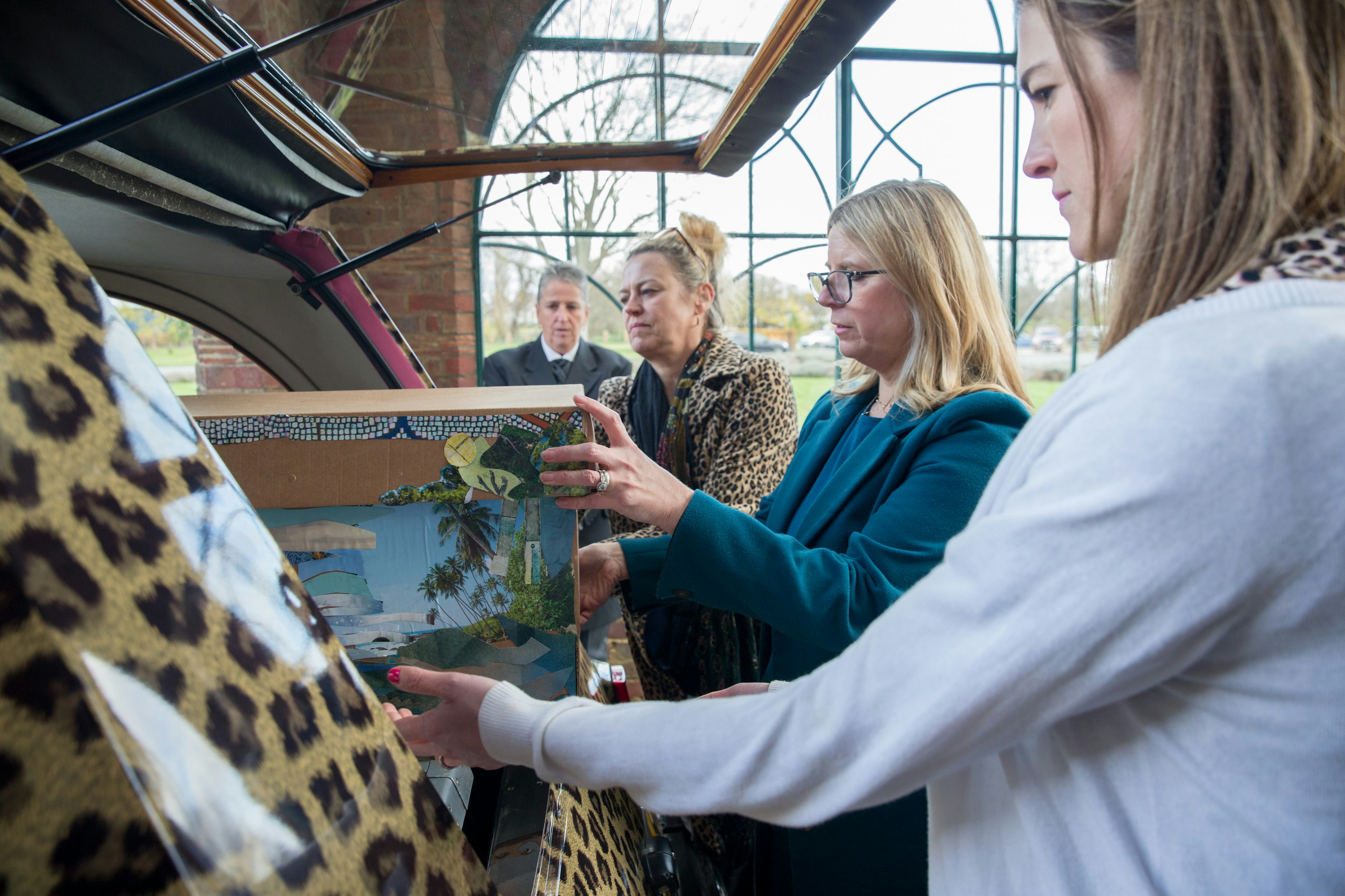 a group of people looking at a painting