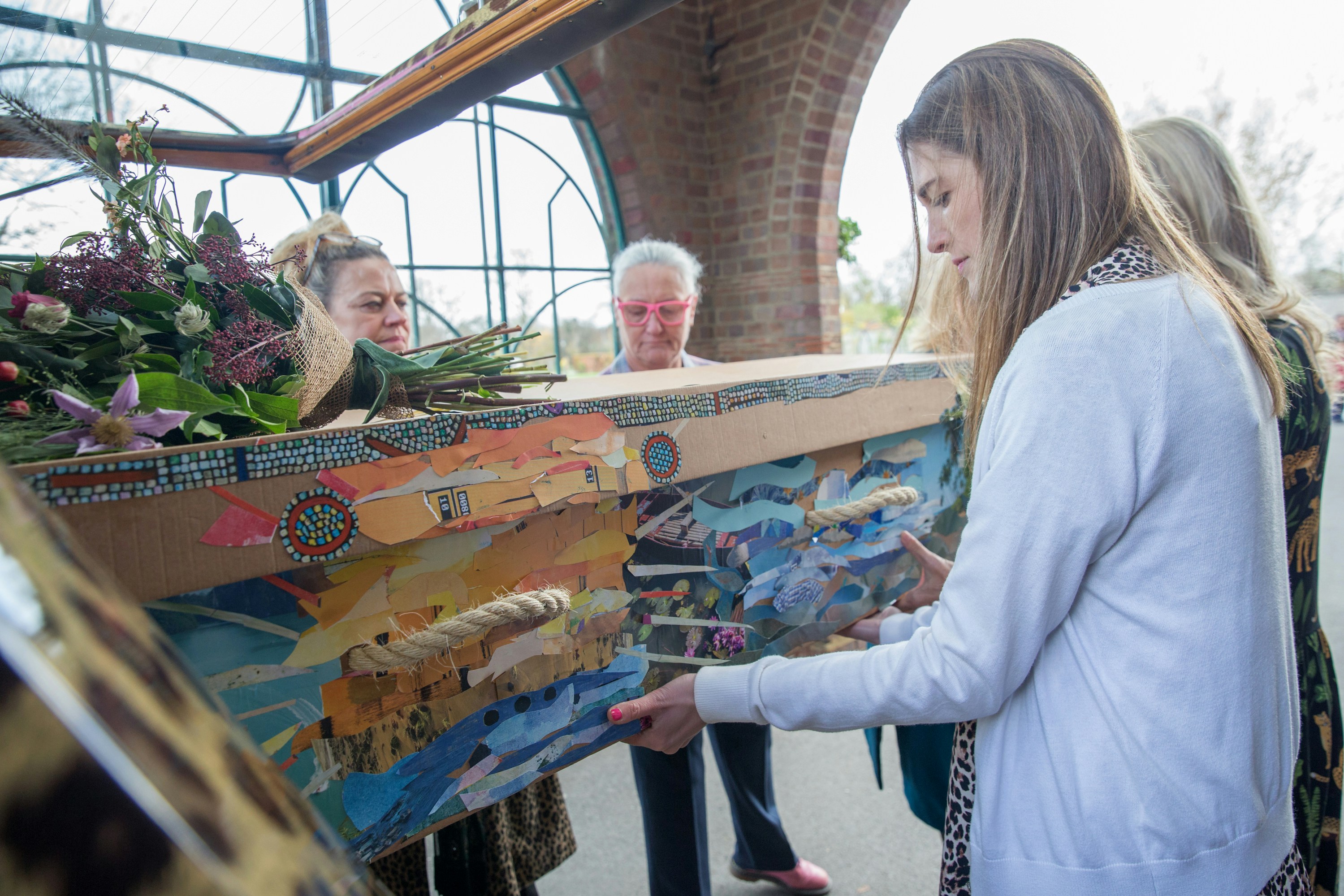 a group of people standing around a painting