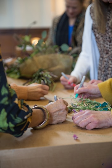 a group of people standing around a table with flowers