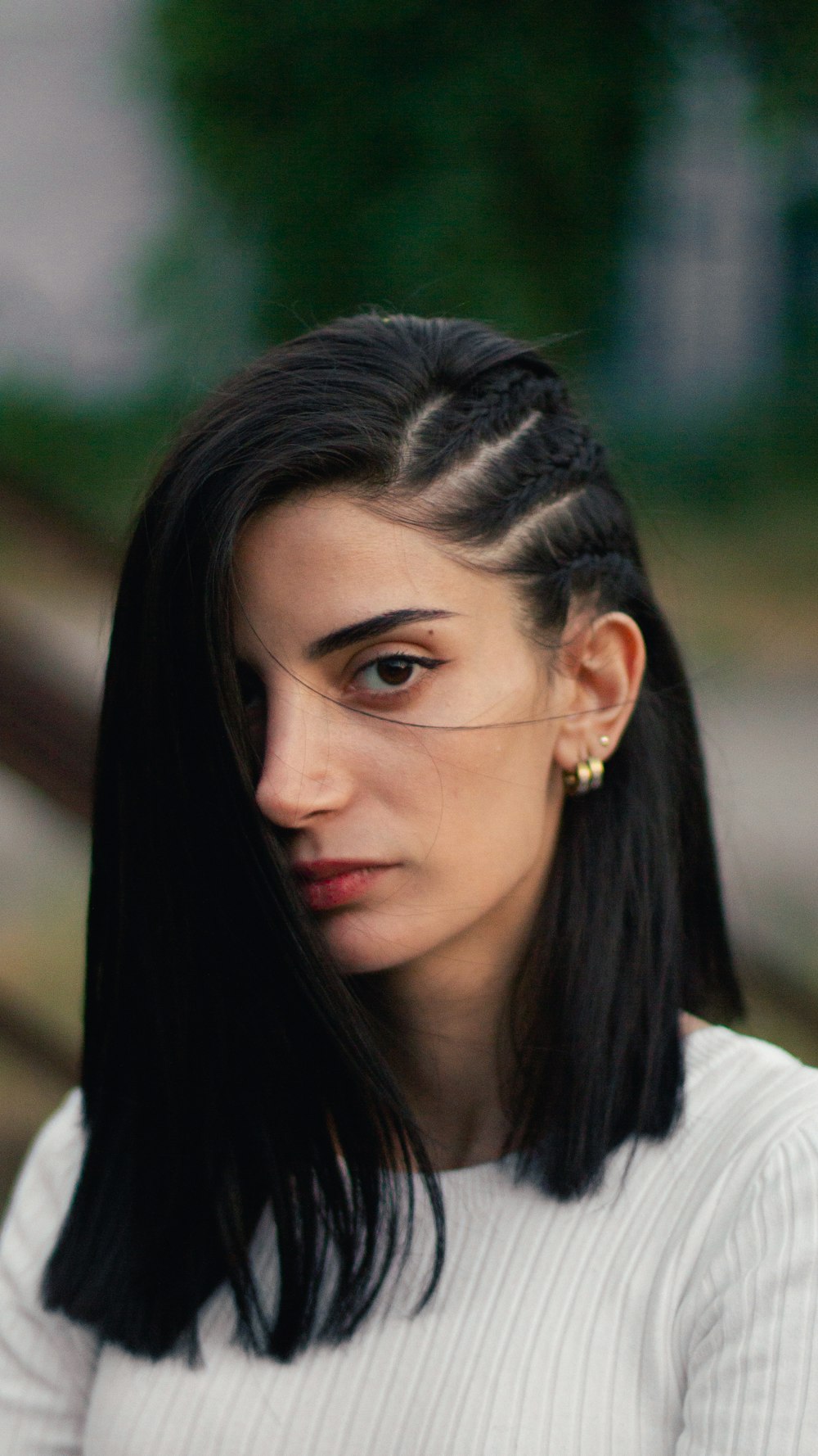 a woman with long black hair wearing a white shirt