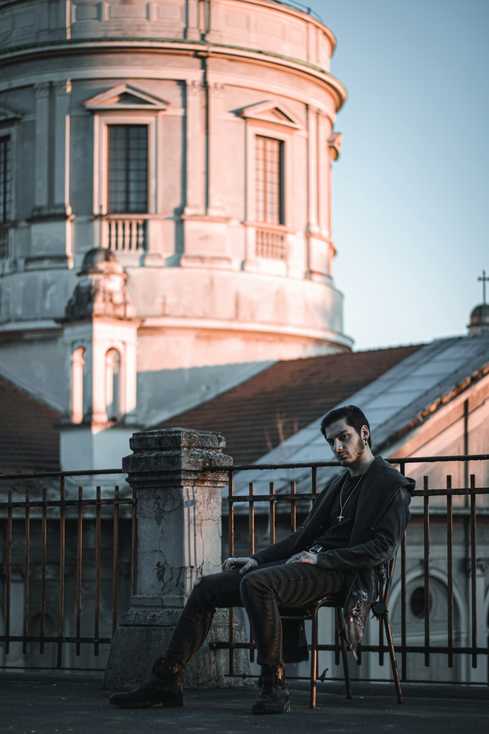 a man sitting on a chair in front of a building