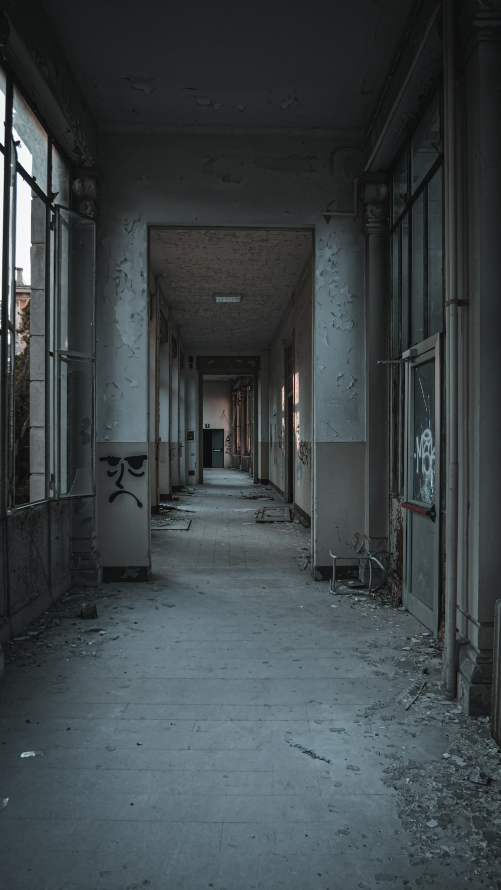 an abandoned building with lots of windows and graffiti on the walls