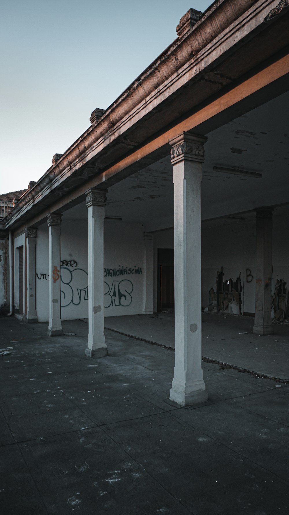 an empty building with columns and graffiti on the walls