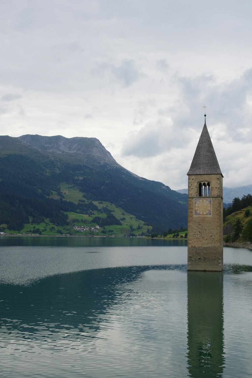 Una torre del reloj sentada en medio de un lago
