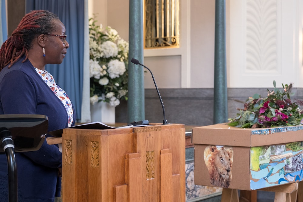 a woman standing at a podium in front of a microphone