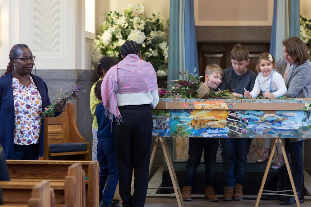 a group of people standing around a table