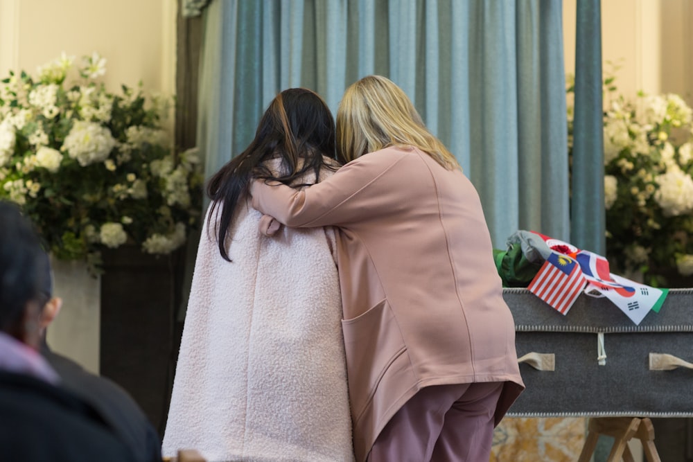 Zwei Frauen umarmen sich bei einer Zeremonie