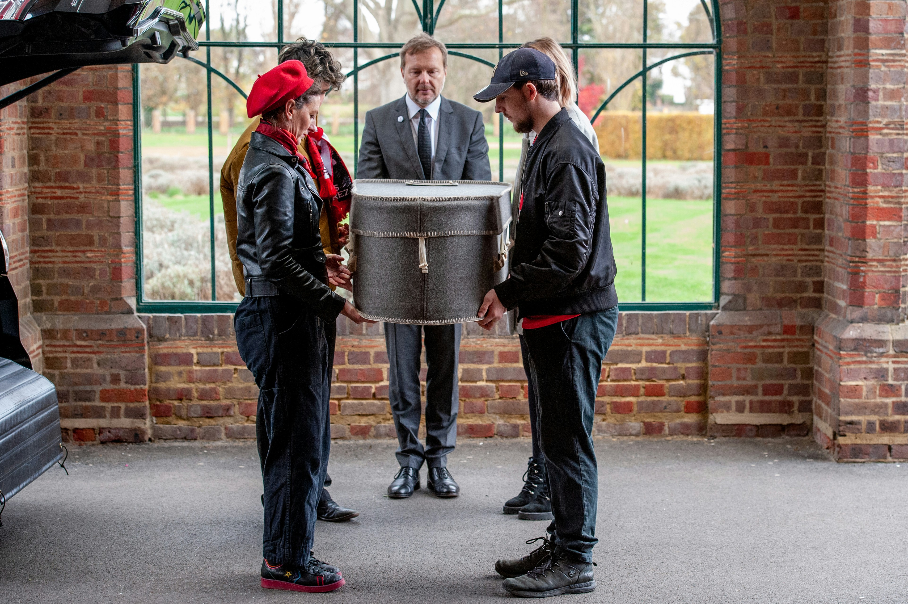 a group of people standing around a trash can