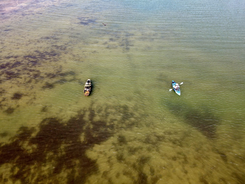 two small boats floating on top of a body of water