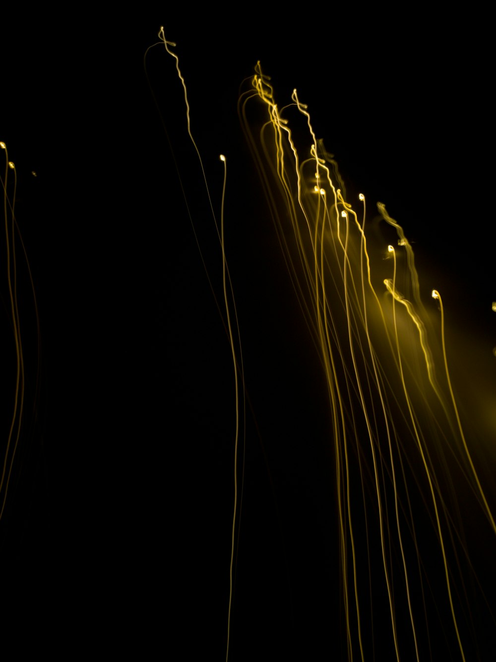 a long exposure of yellow lights on a black background