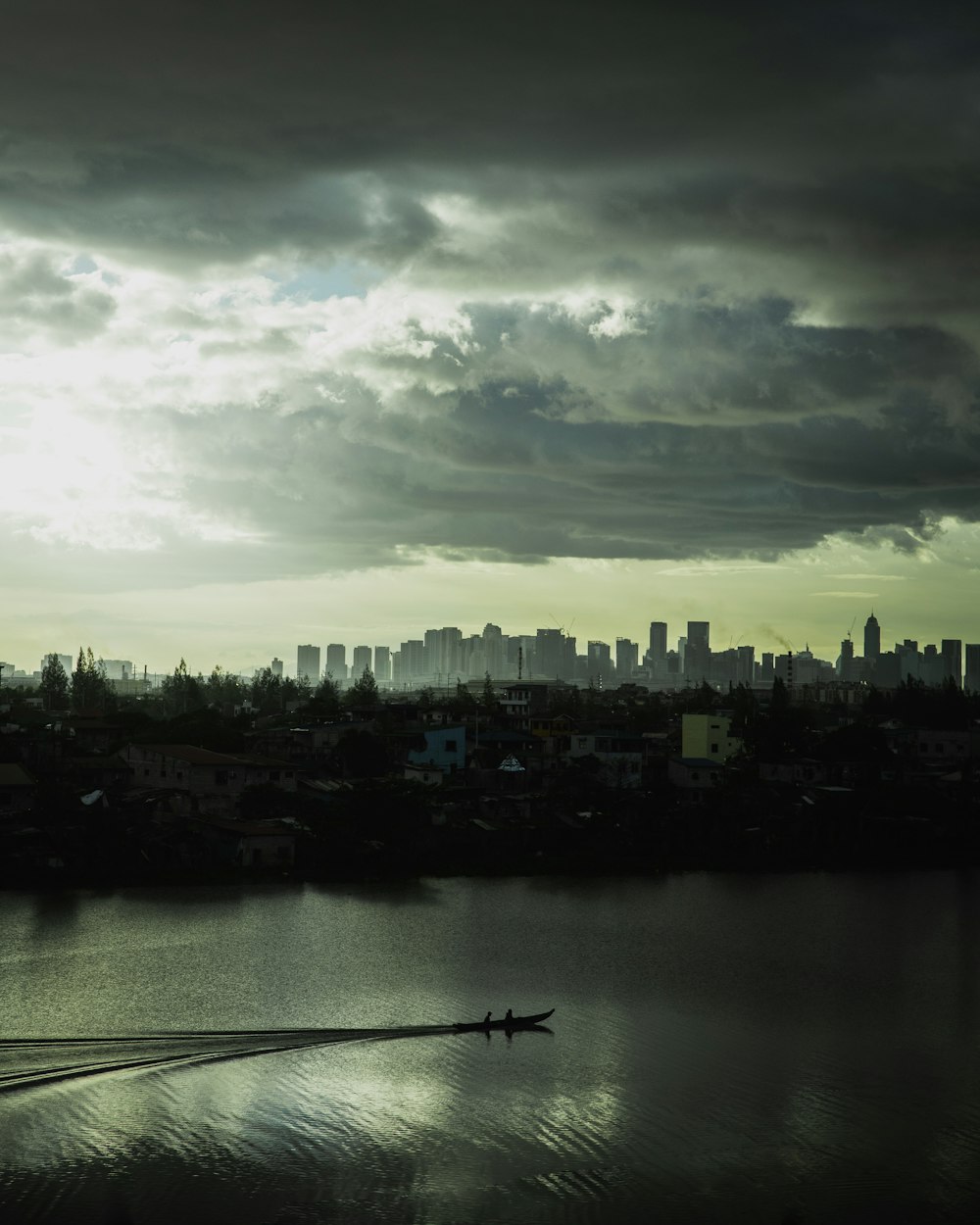 a boat traveling across a large body of water under a cloudy sky