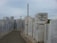 A series of marble monuments with engraved names line a pathway. Each monument slab stands upright, displaying numerous names, likely serving as a memorial. The largest slab foregrounds an inscription in Turkish, indicating it's a monument commemorating an earthquake that occurred on August 17, 1999 in Yalova. The sky is overcast, adding a somber tone to the setting.
