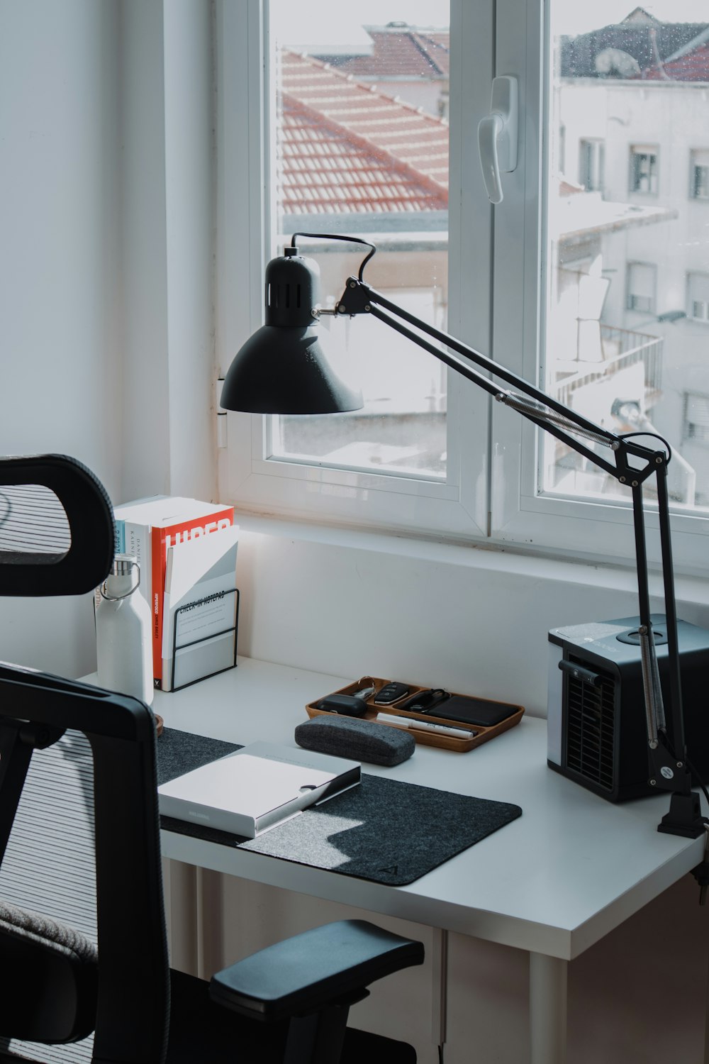 a desk with a lamp and a computer on it