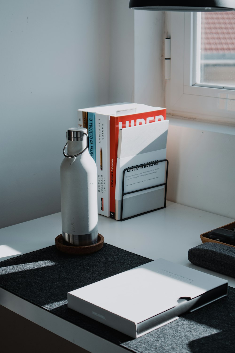 a white table with a book and a bottle on it