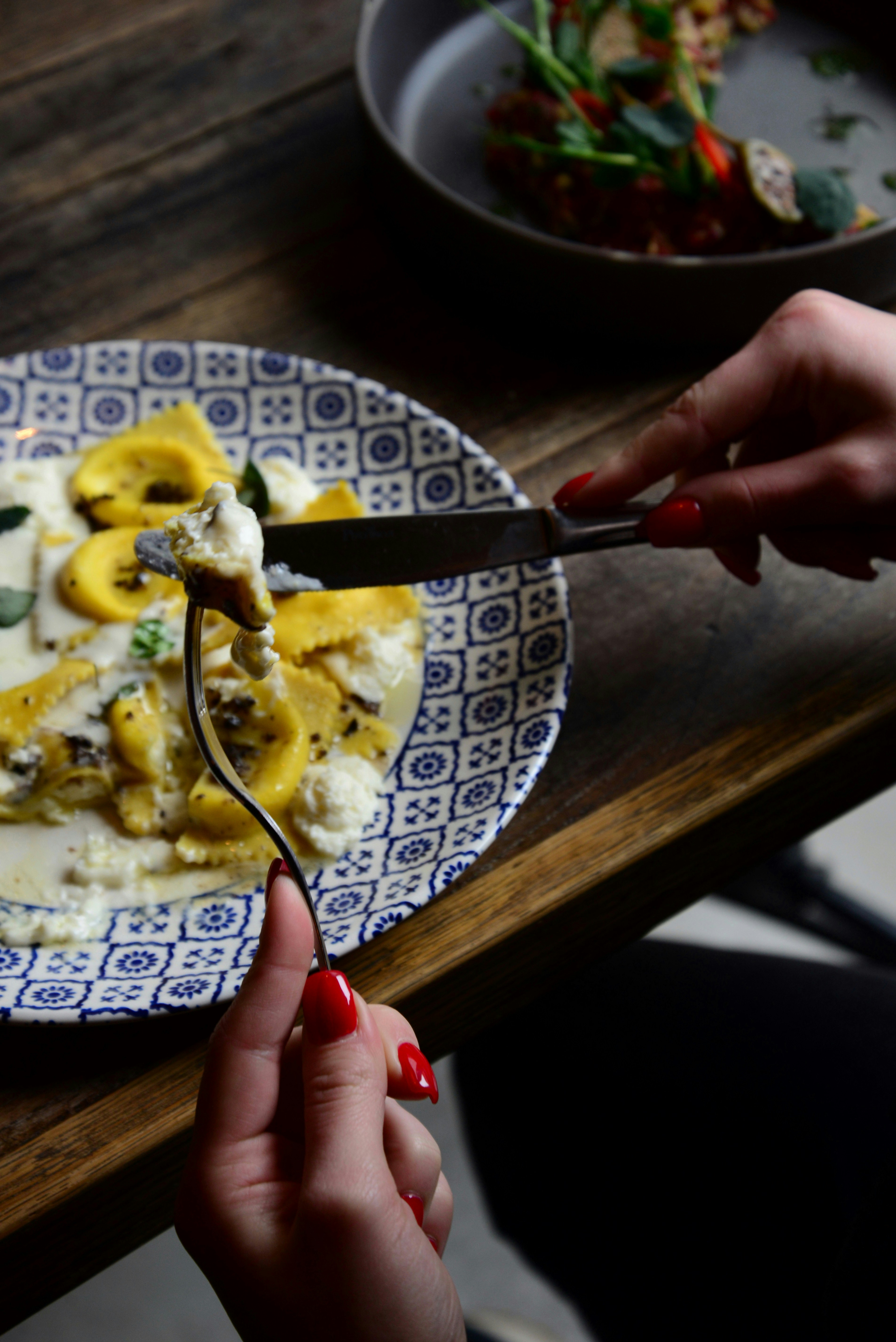 a woman is cutting a piece of food on a plate