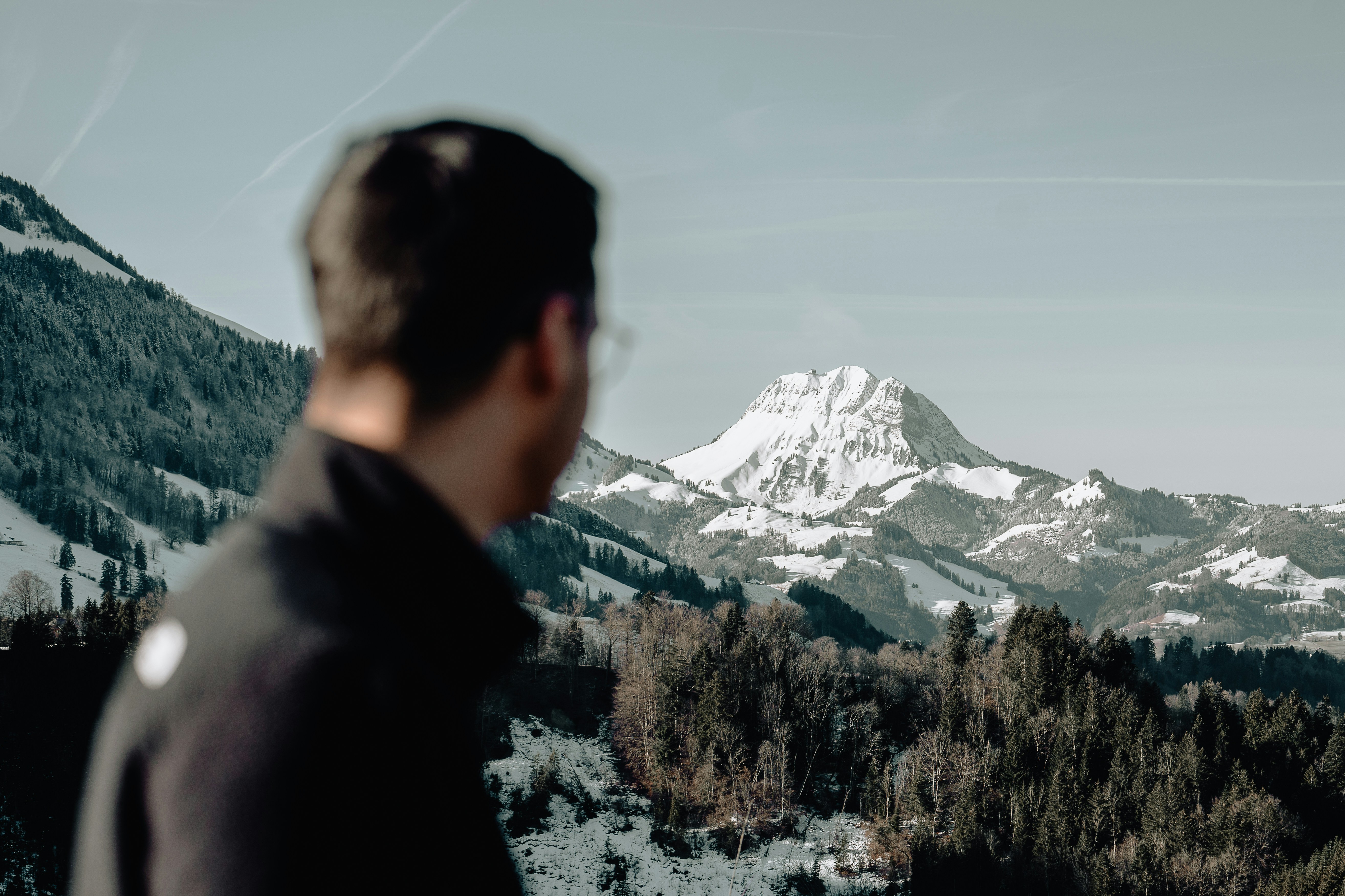 a man standing in front of a snow covered mountain