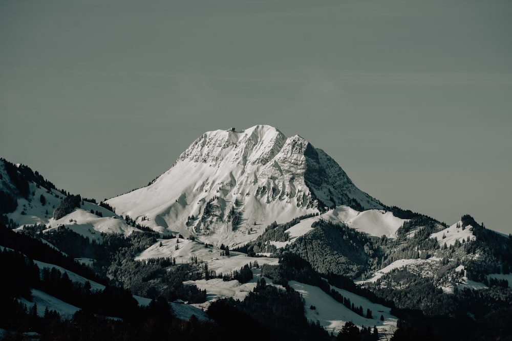 a mountain covered in snow with a sky background