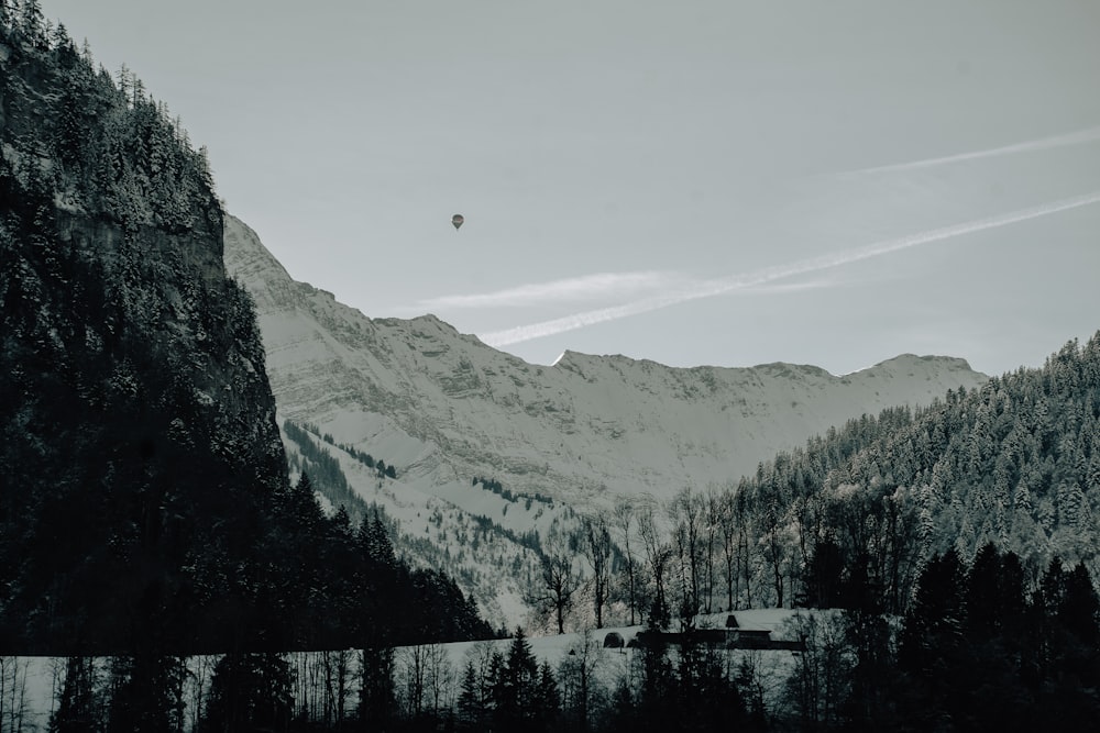 a hot air balloon flying over a mountain range