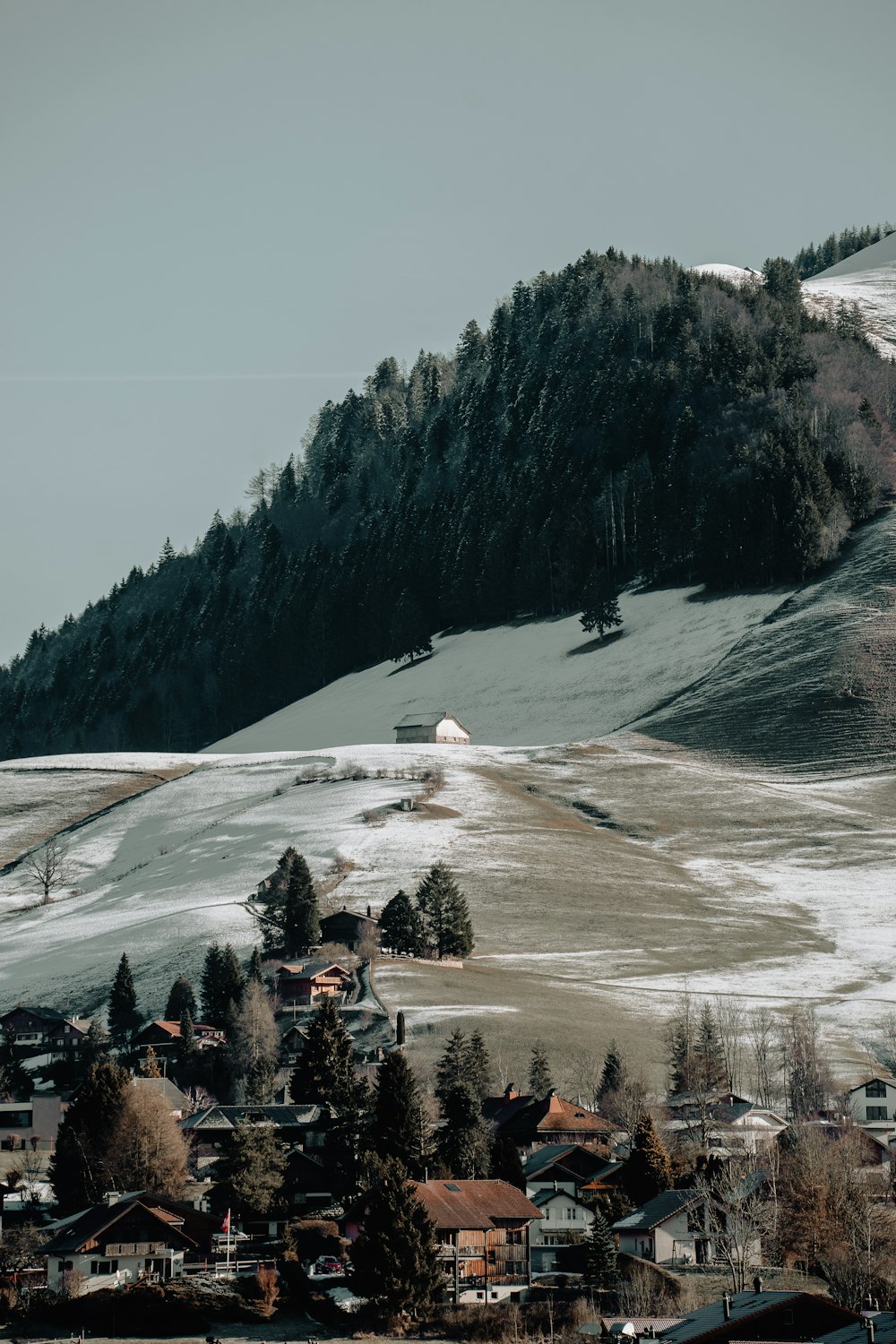 a snow covered mountain with a village below