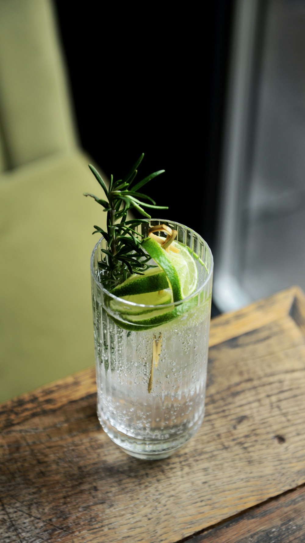 a glass filled with a drink sitting on top of a wooden table