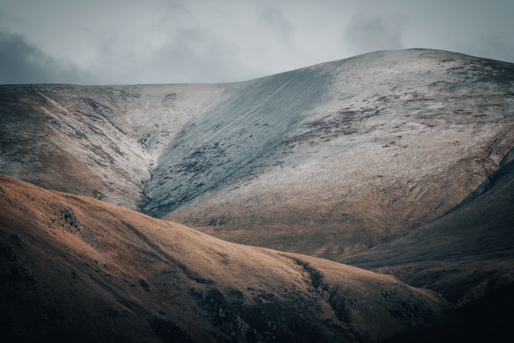 a mountain covered in snow under a cloudy sky