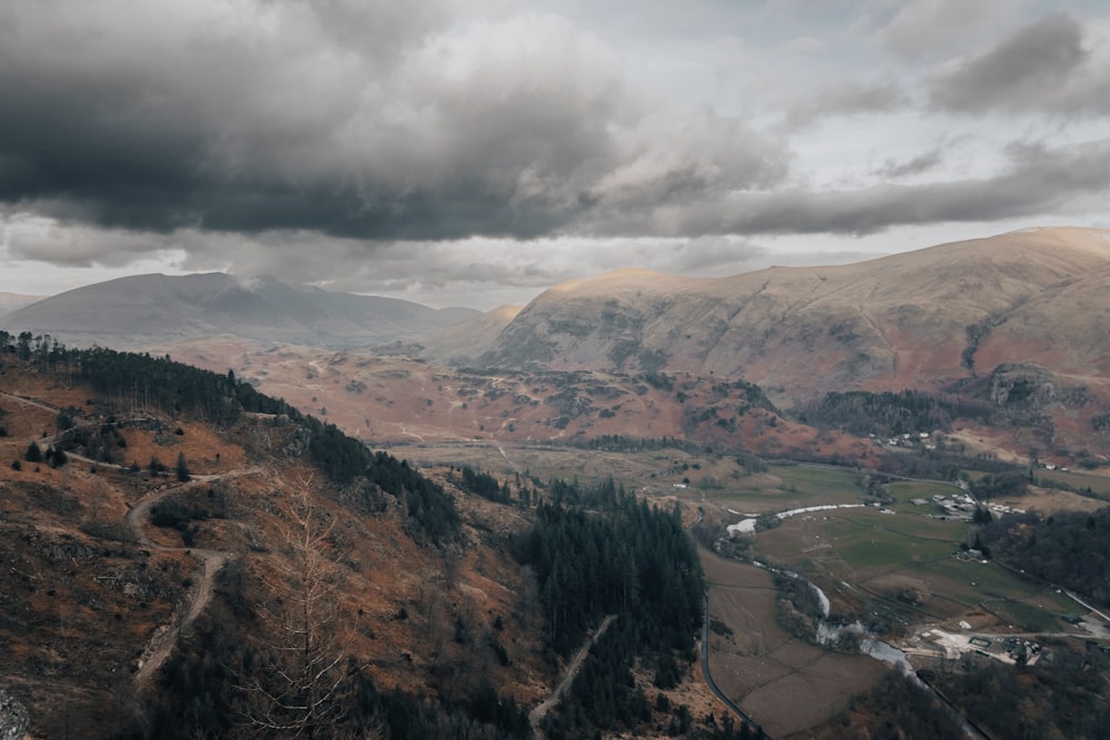 a scenic view of a valley with mountains in the background