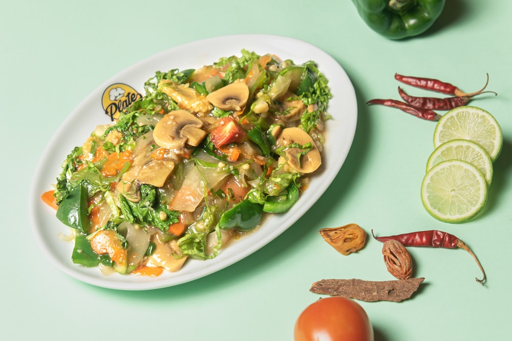 a white plate topped with a salad covered in mushrooms