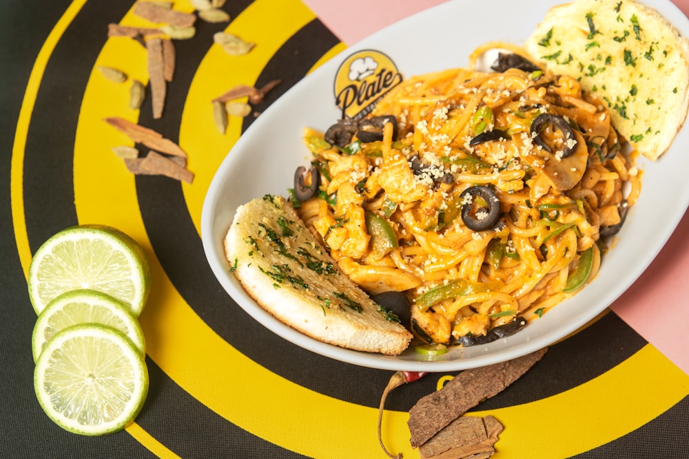 a plate of pasta and a slice of lime