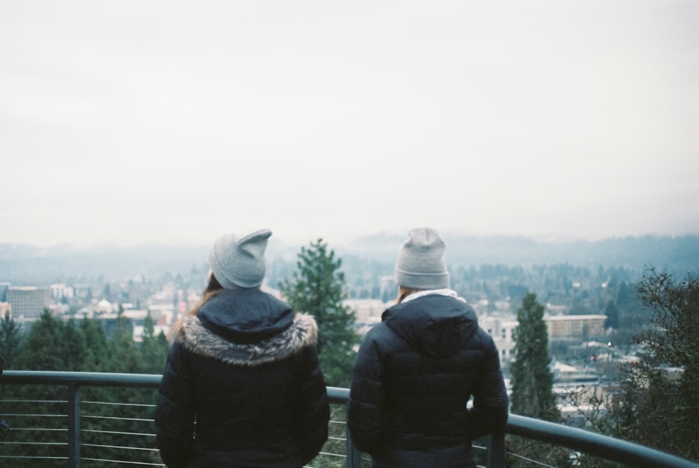 a couple of people standing on top of a hill