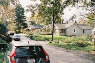 A calm suburban street with well-maintained single-family homes under a clear sky