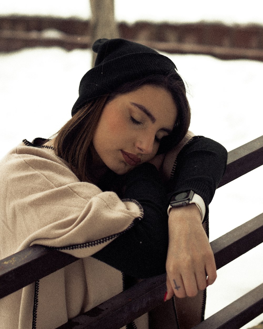 a woman sitting on a bench in the snow