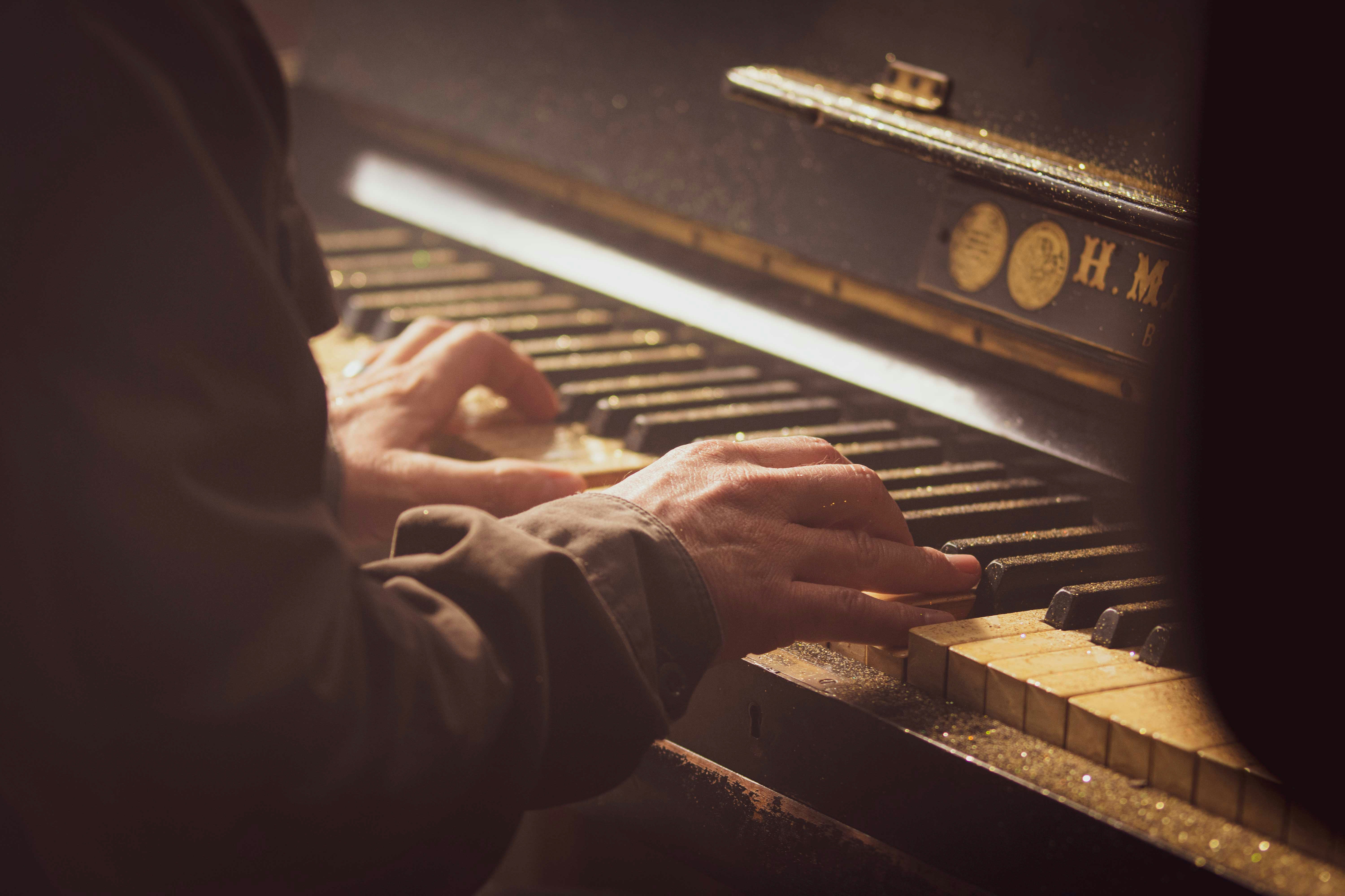 A person recording piano to create epic soundtrack music, which will be part of a library of royalty free soundtrack music for film projects