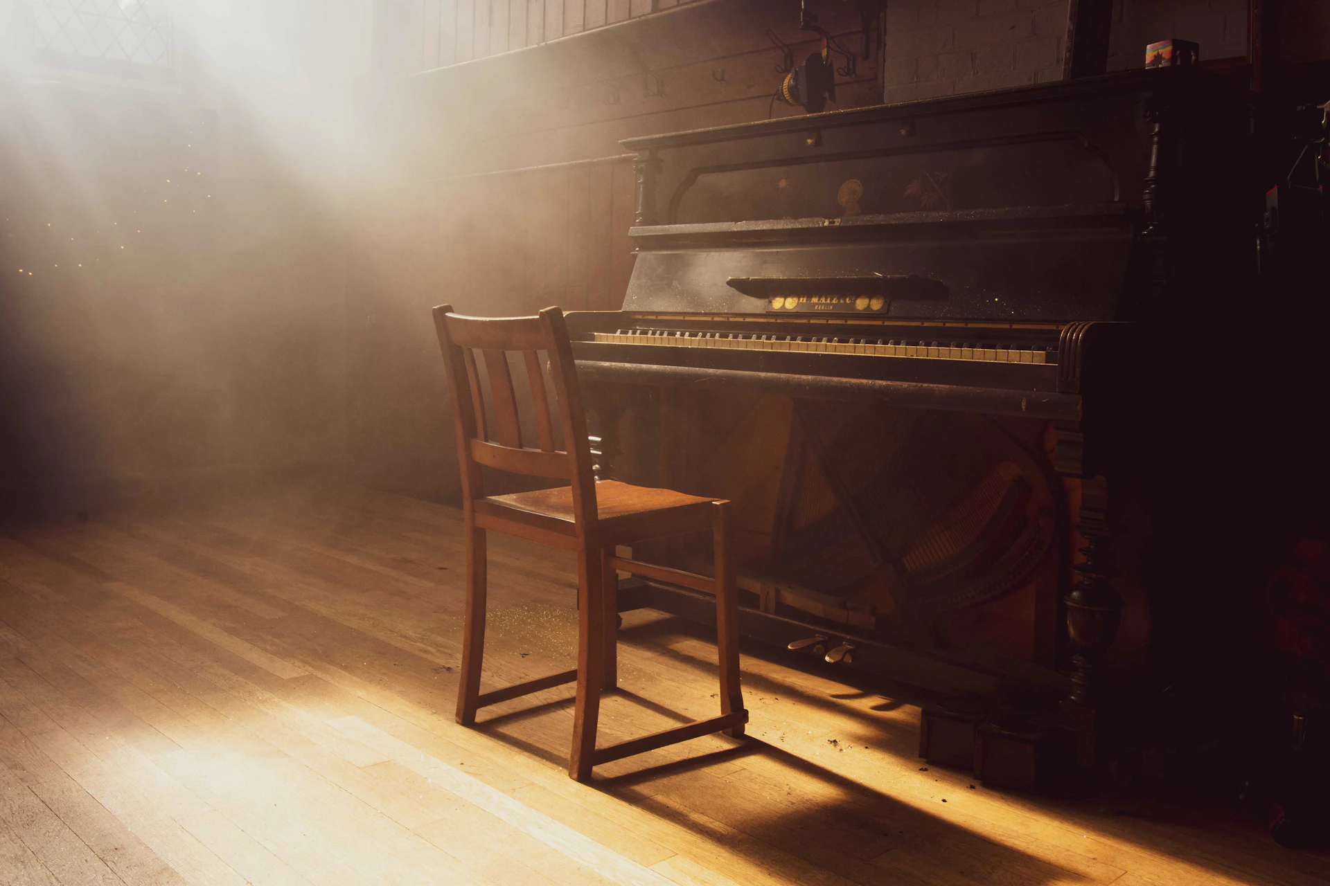 a chair sitting next to a piano on a hard wood floor