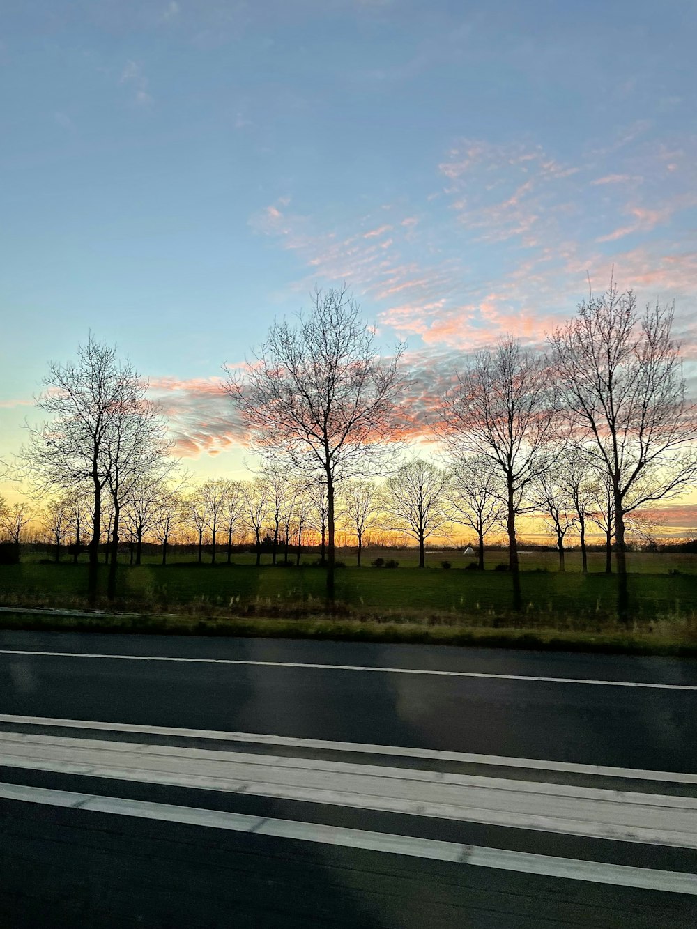 a picture of a sunset taken from a car window