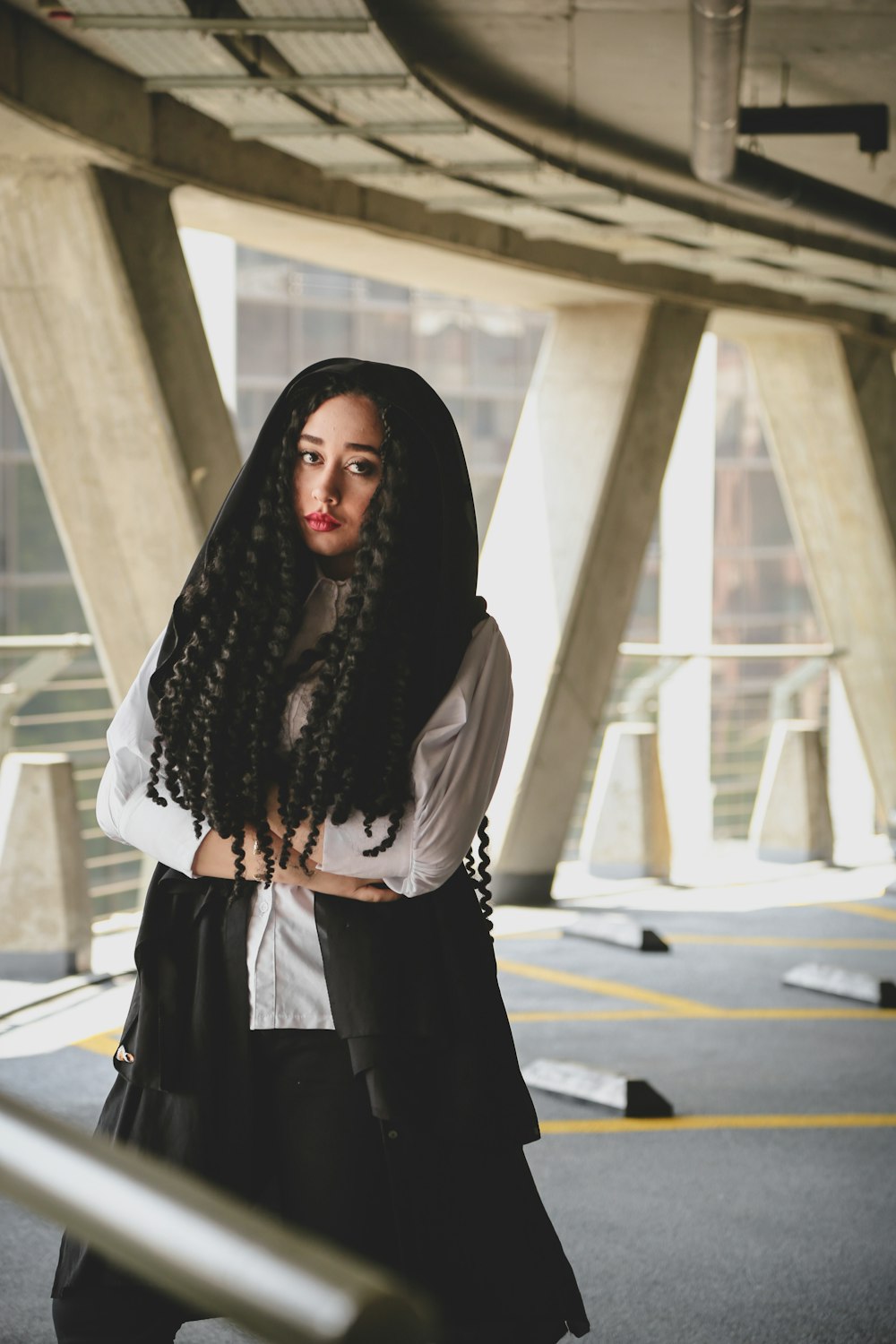 a woman with long curly hair standing in a parking lot