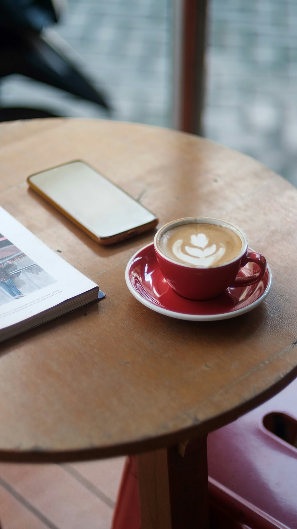 a cup of coffee sitting on top of a wooden table