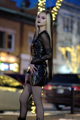 a woman with long hair and makeup is standing on the street