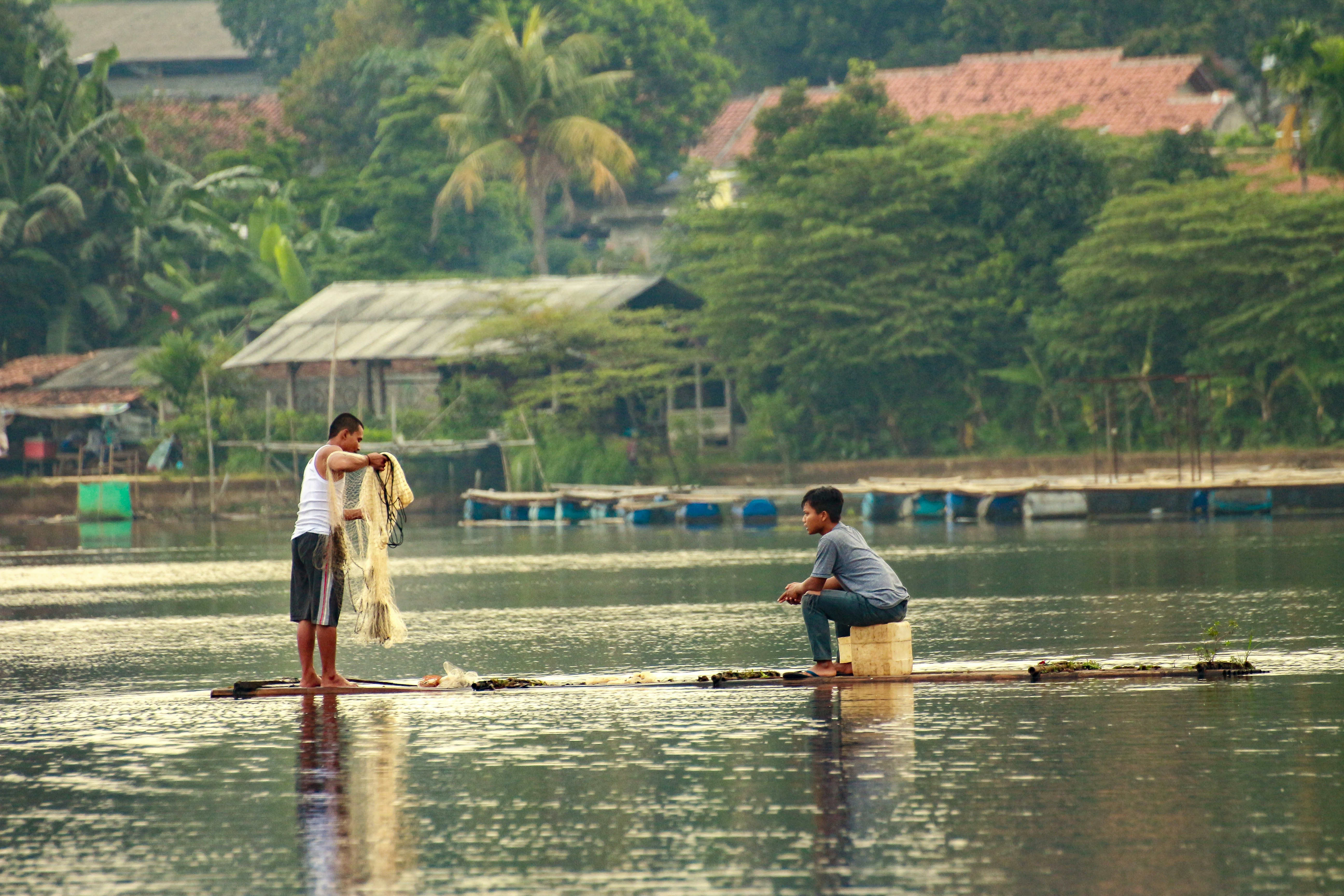 A man and a woman standing on a raft in the water photo – Free ...