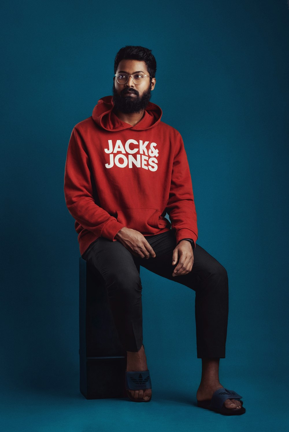 a man with a beard sitting on a stool