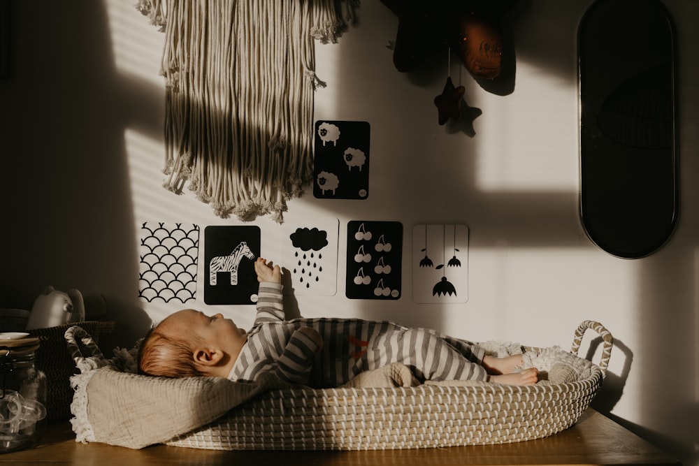 a baby is sleeping in a basket on a table